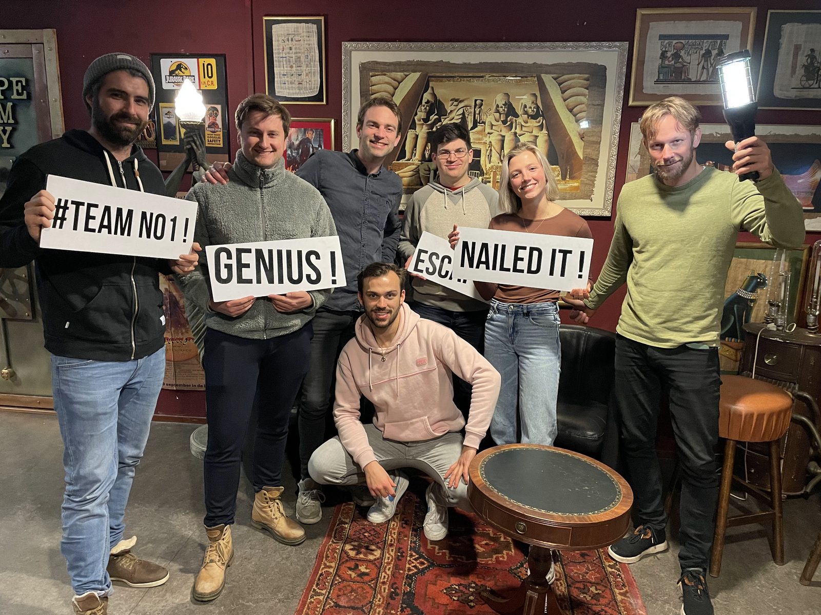 The Koalitix team after an escape room, holding signs that say “#Team No1”, “Genius!” and “Nailed it!”.